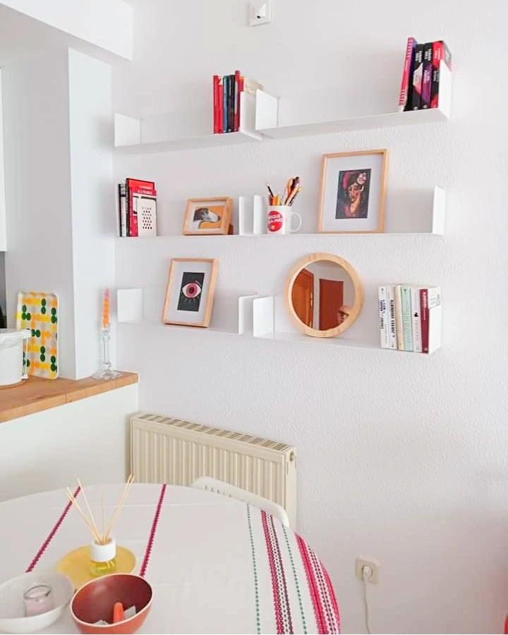 Estantería blanca de cocina en pared con taza libros y decoración, estilo moderno minimalista