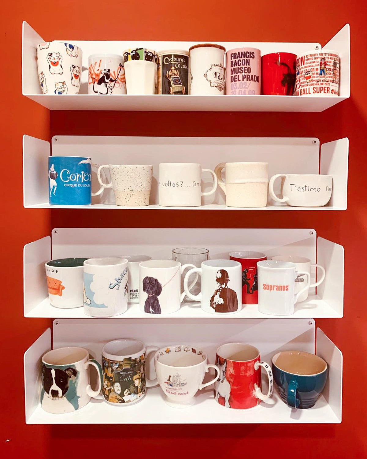 Estantería metálica blanca de cocina con tazas en pared